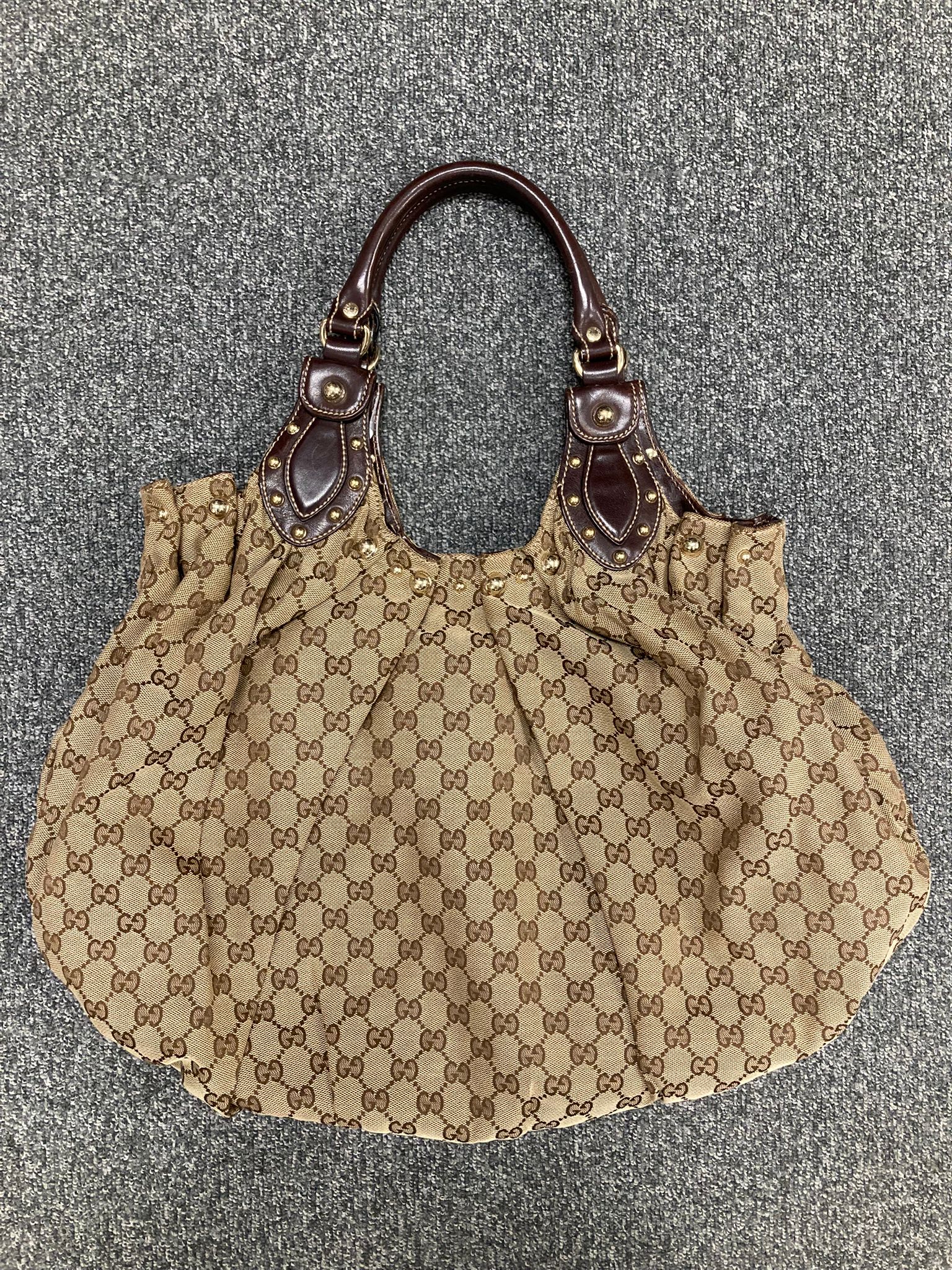 Gucci Pelham GG canvas y tachuelas